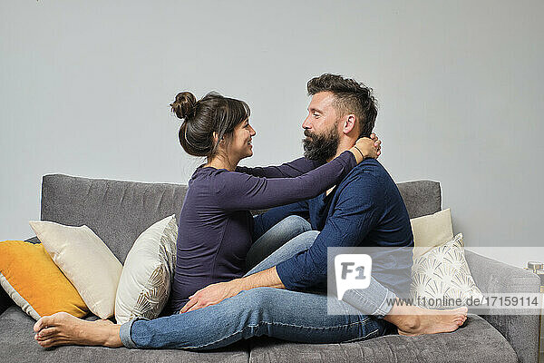 Adult couple sitting together on sofa