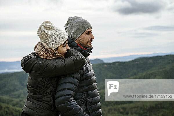 Touristenpaar schaut weg  während es an einem Aussichtspunkt gegen den Himmel steht
