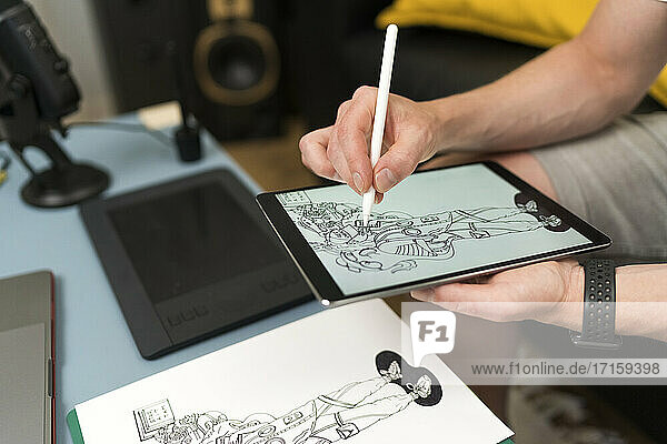 Artist drawing on digital tablet while live streaming sitting at home