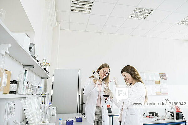 Scientists in white coats doing experiment in lab