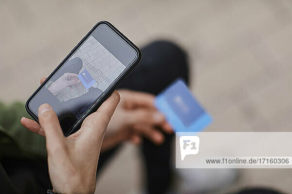 Man taking photo of credit card through smart phone