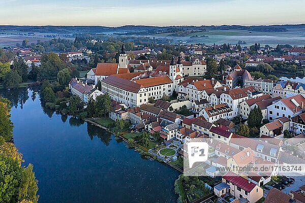 Aerial view of the castle  watch towers and chateau along with the red tile roofs and medieval square in the town of Telc in the Czech Republic.