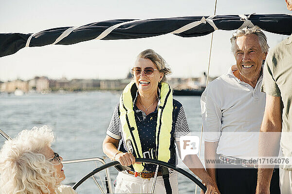 Fröhliche ältere Frau Segelboot mit glücklichen Freunden auf sonnigen Tag