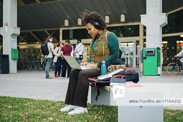 Junge Studentin beim E-Learning mit Laptop auf dem Campus