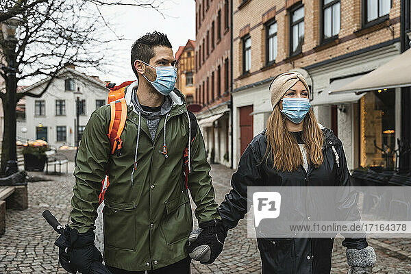 Weibliche und männliche Touristen erkunden die Stadt während der Pandemie