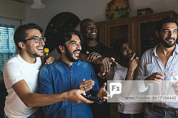 Male friends watching tv together