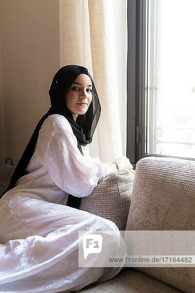 Junge muslimische Frau entspannt sich zu Hause