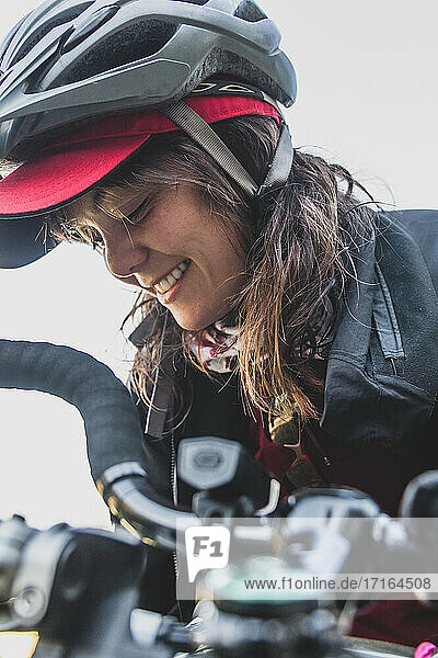 Frau auf ihrem Fahrrad  mit Helm  lächelnd