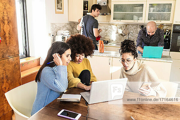 Mitbewohner in der Küche  mit Laptops  per Videoanruf