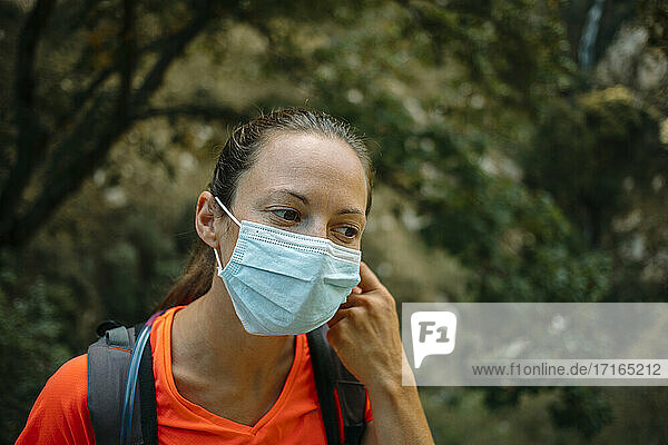 Woman wearing protective face mask looking away while hiking at Cares Trail in Picos De Europe National Park  Asturias  Spain