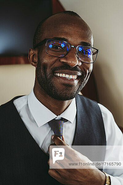 Lächelnder männlicher Unternehmer mit Krawatte im Flugzeug