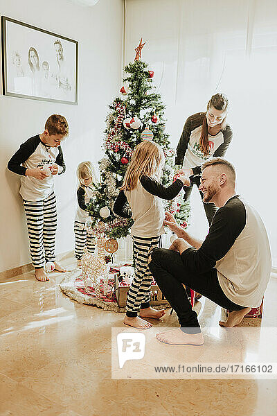 Happy family decorating Christmas tree together at home