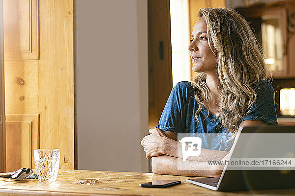 Businesswoman with arms crossed looking away at home