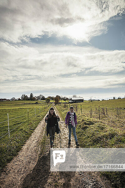 Girls exploring while walking by agricultural field at countryside