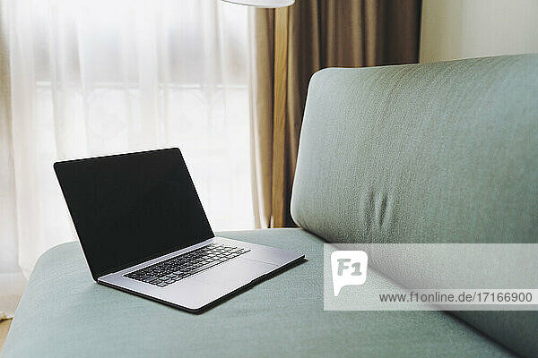 Laptop on sofa in hotel room