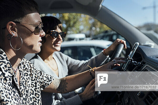 Frau  die ein Mobiltelefon benutzt  während sie mit einem Freund im Auto sitzt