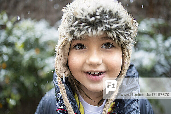 Cute girl in knit hat during snow