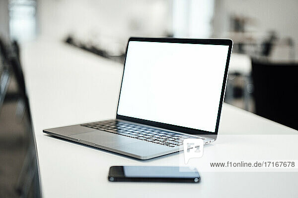 Laptop und Smartphone auf dem Tisch im Büro