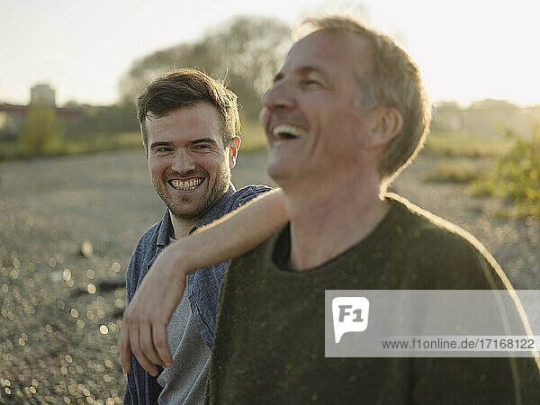 Father and son laughing at riverbank