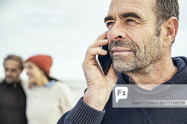 Porträt eines Mannes  der mit einem Smartphone spricht