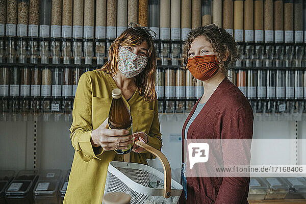 Female friends in mask shopping together in retail store