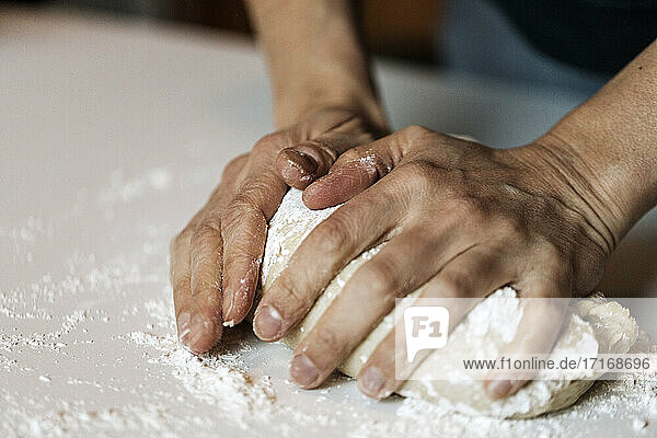 Woman kneading dough for cinnamon rolls