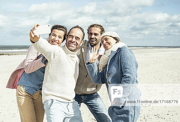 Group of friends taking selfie at beach