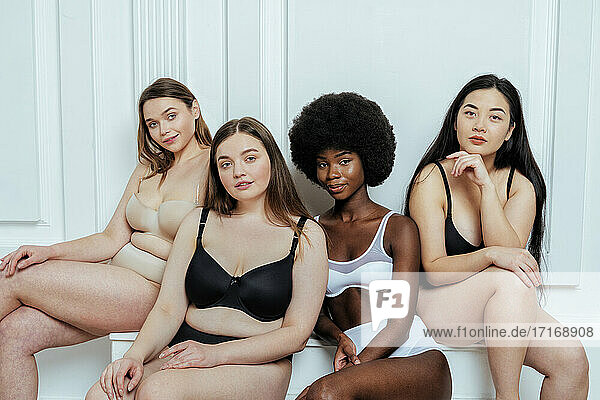 Schöne multi-ethnische Gruppe von Mode-Modelle in Dessous gegen weiße Wand