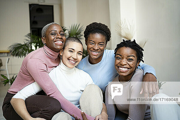 Smiling female friends sitting in living room at home