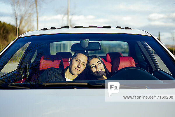 Young couple smiling while sitting in car