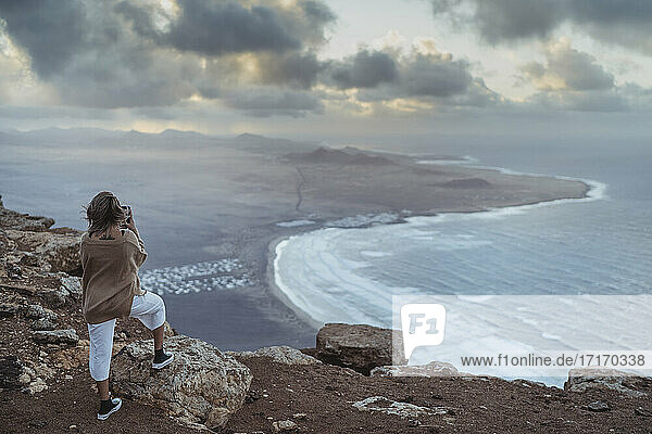 Tourist mit Blick auf die Famara-Aussicht  während er auf einem Berg auf Lanzarote  Spanien  steht