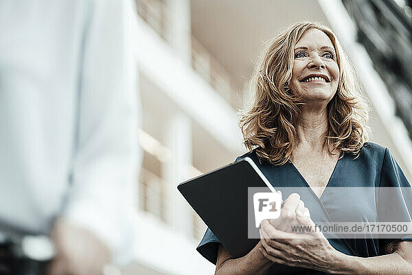 Lächelnde ältere Geschäftsfrau  die in den Korridor blickt