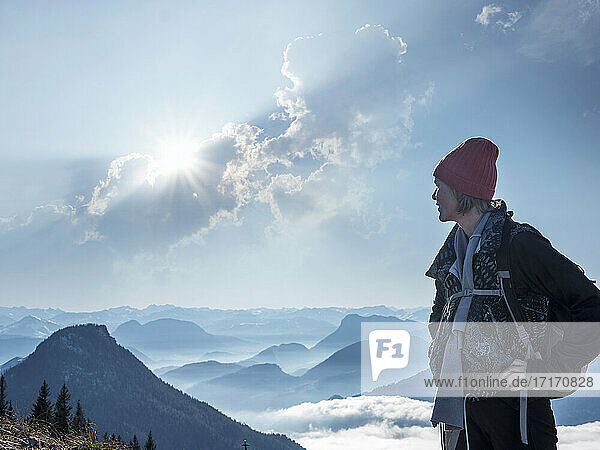 Female tourist standing on Heuberg mountain against cloudy sky during sunny day
