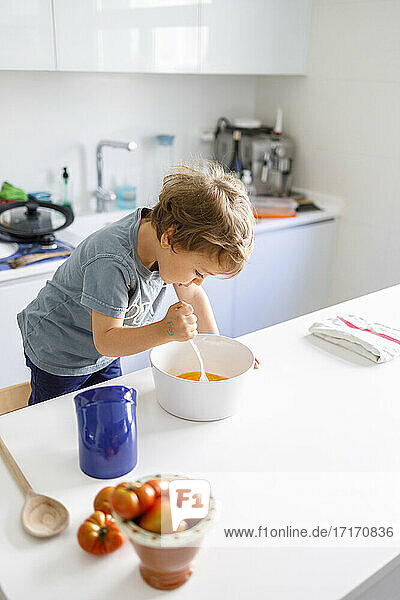 Kleiner Junge beim Kochen in der Küche zu Hause