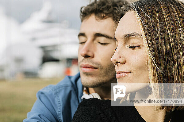 Young couple with eyes closed outdoors