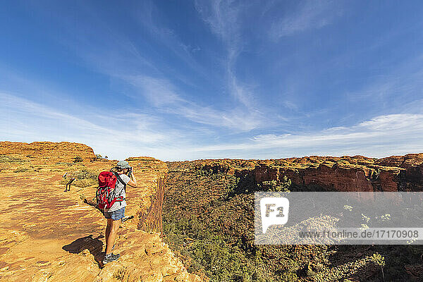 Female hiker photographing landscape of Kings Canyon