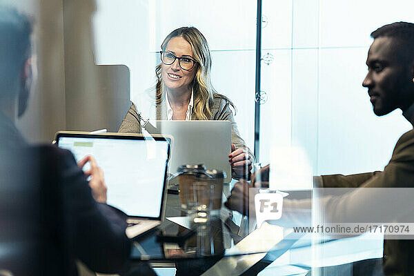 Businesswoman smiling while working with colleague in office