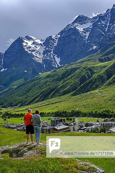 Italy  Valtournenche  Man and woman admiring landscape surrounding Breuil-Cervinia resort in spring