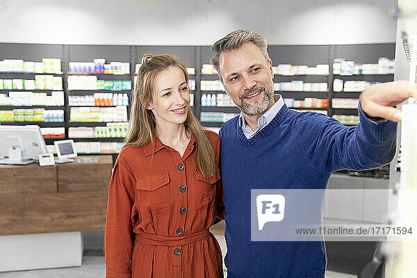 Smiling couple purchasing medicine at pharmacy