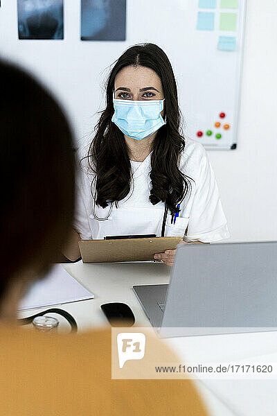 Ärztin im Gespräch mit einem Patienten in einer Klinik während der Pandemie