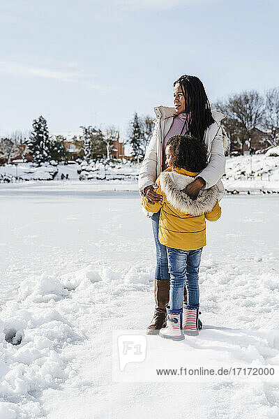 Mutter und Tochter schauen weg  während sie im verschneiten Land stehen