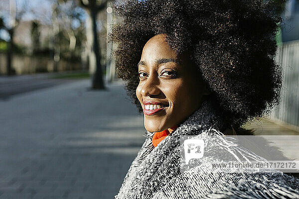 Glückliche junge Afro-Frau auf der Straße an einem sonnigen Tag