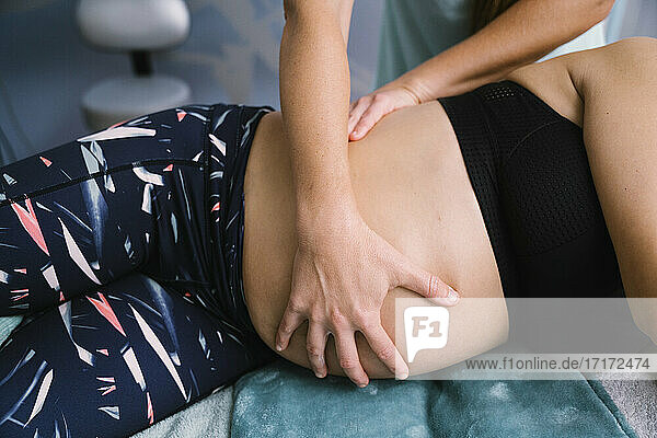 Female nurse examining pregnant patient while exercising at hospital
