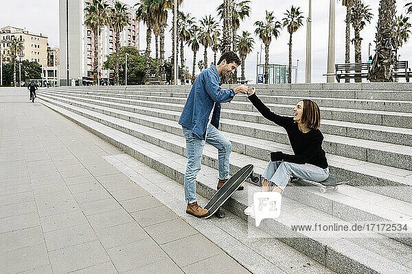 Paar mit Skateboards Fauststöße im Freien