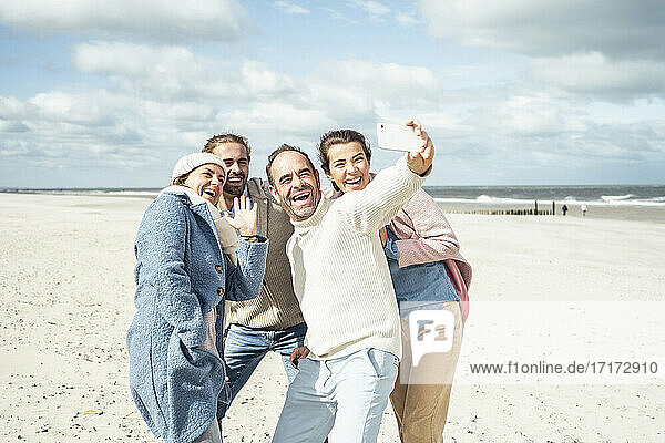 Group of friends taking selfie at beach