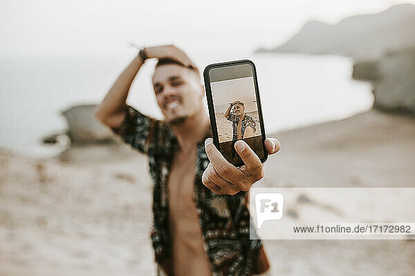 Young man taking selfie through smart phone at Almeria  Tabernas desert  Spain