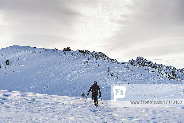 Male skier climbing at Pyrenees during sunrise
