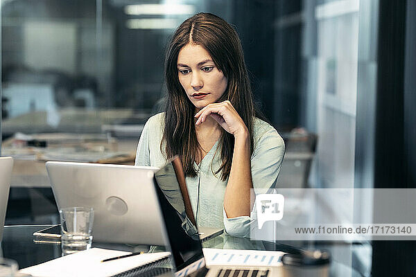Young businesswoman working on laptop while sitting at office