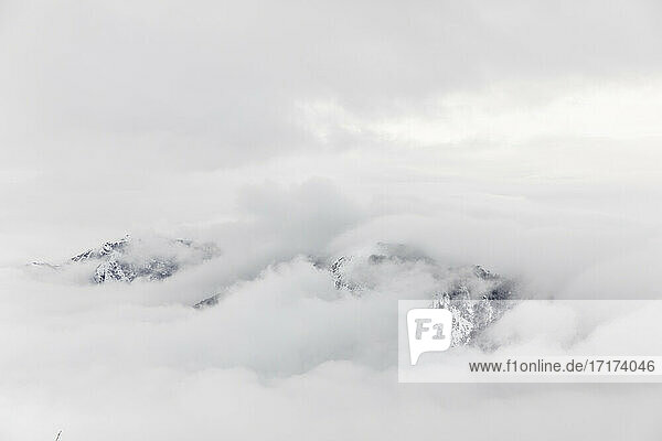 Clouds covering snowcapped mountain