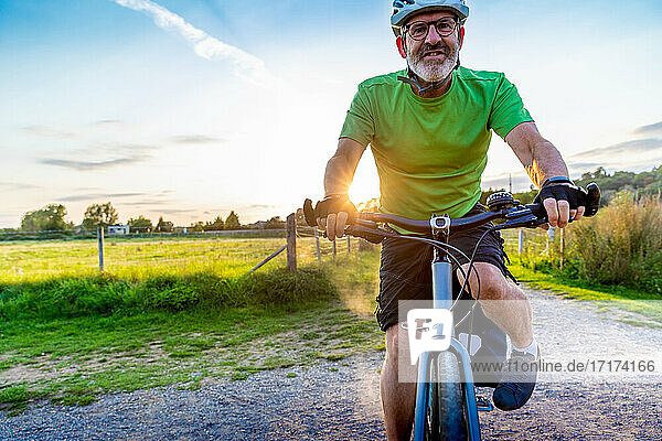 Älterer Mann beim Mountainbiking auf dem Lande